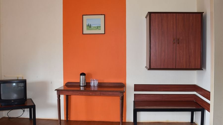 A room at Wind Chalet Resort featuring three sets of tables next to each other: one with a TV, another with essentials, and the third placed beneath a wall-mounted wooden cupboard.