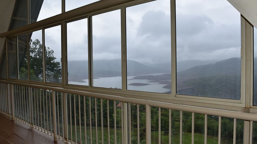 View of Koyna Dam from Wind Chalet Resort, framed by the grills and panels of the building.
