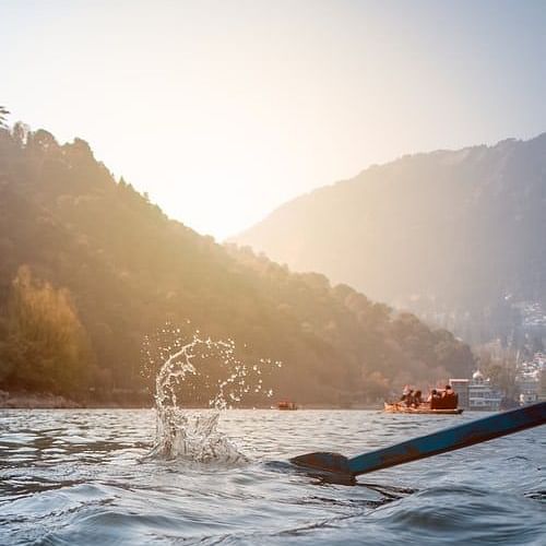 oar moving the boat in a mountain covered lake