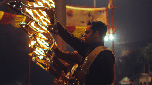 A Person knelling down and performing a Hindu ritual with lights - Ramgarh Bungalows, Nainital.
