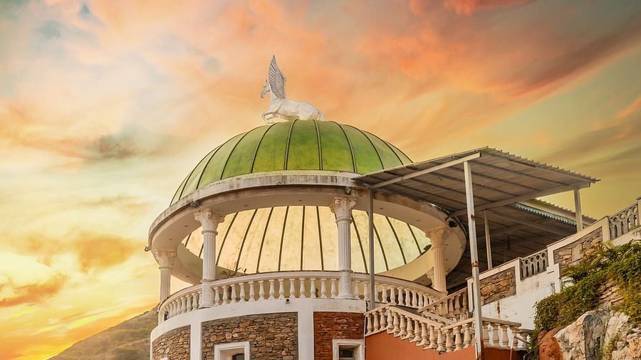 An image of the hotel entrance with an open gate, a dome structure, and a beautiful evening sky