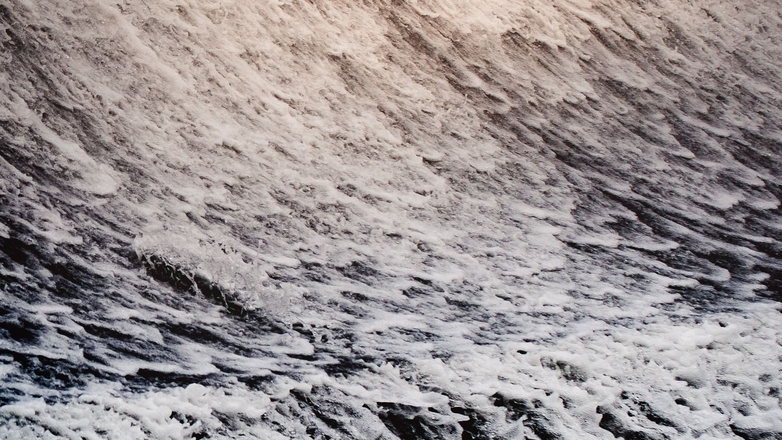 a close up shot of the water flowing down Bhushi Dam with the sun rays hitting the water.