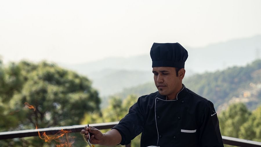 A person grilling barbecue on the terrace at BluSalzz Escapade Resort, Lansdowne