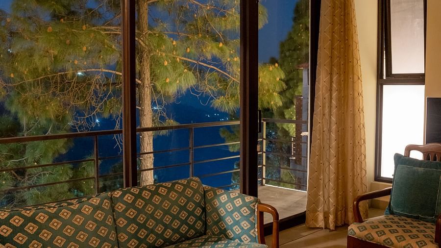 A suite living room featuring sofas, a table, and a glass window in the background at BluSalzz Escapade Resort, Lansdowne