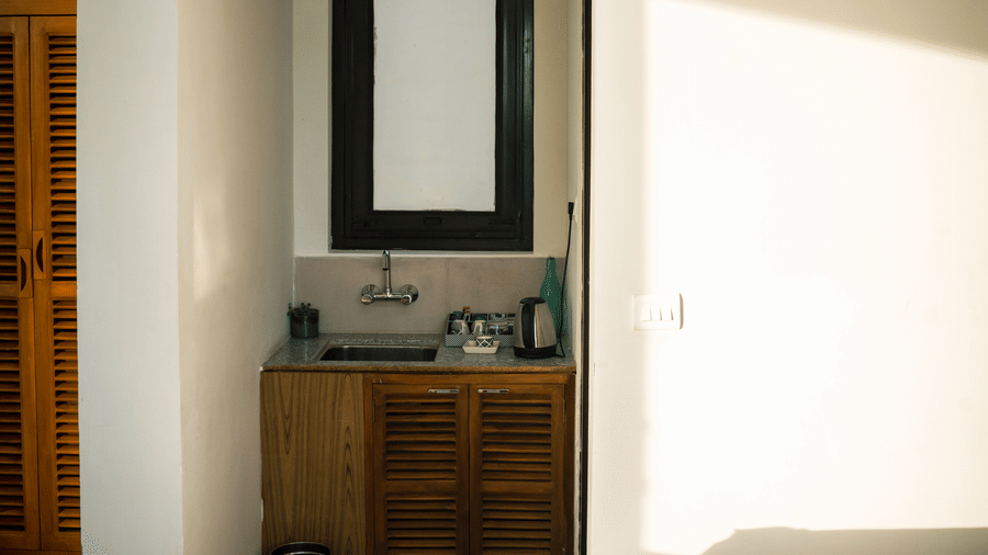 An interior view shows a bed with a runner and a counter with a sink and mirror in the Pine Forest Suite.