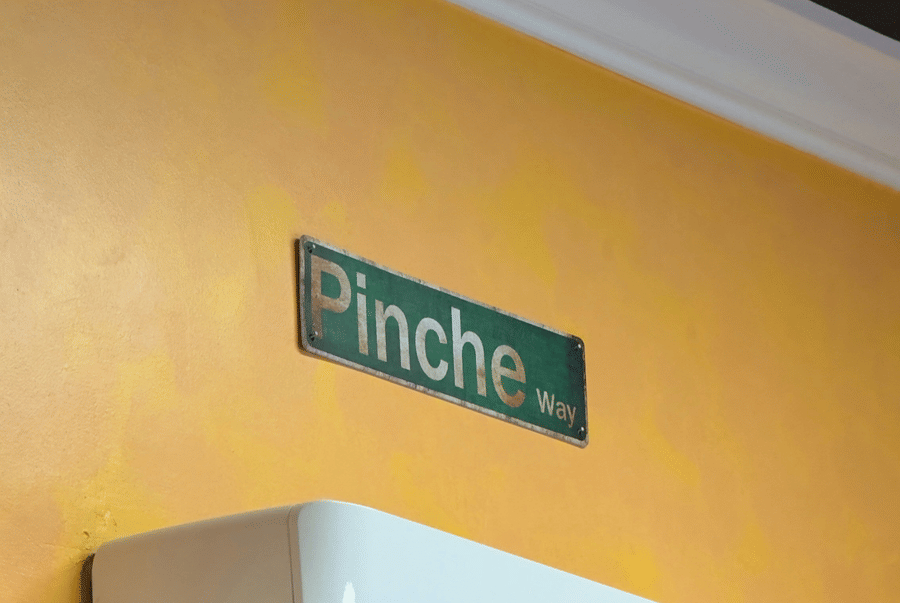 A wall-mounted air-conditioner placed on a yellow coloured wall.