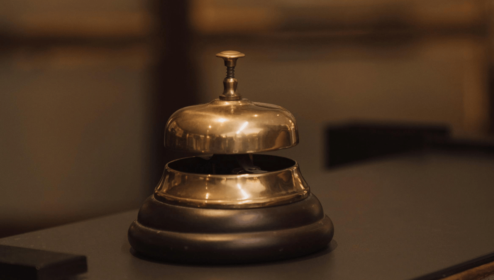 A metal service bell placed on a polished counter.