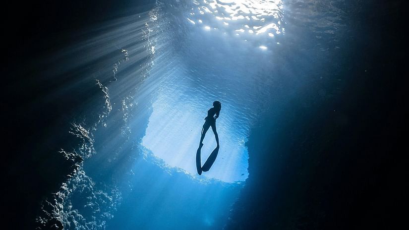 A person scuba diving under water.