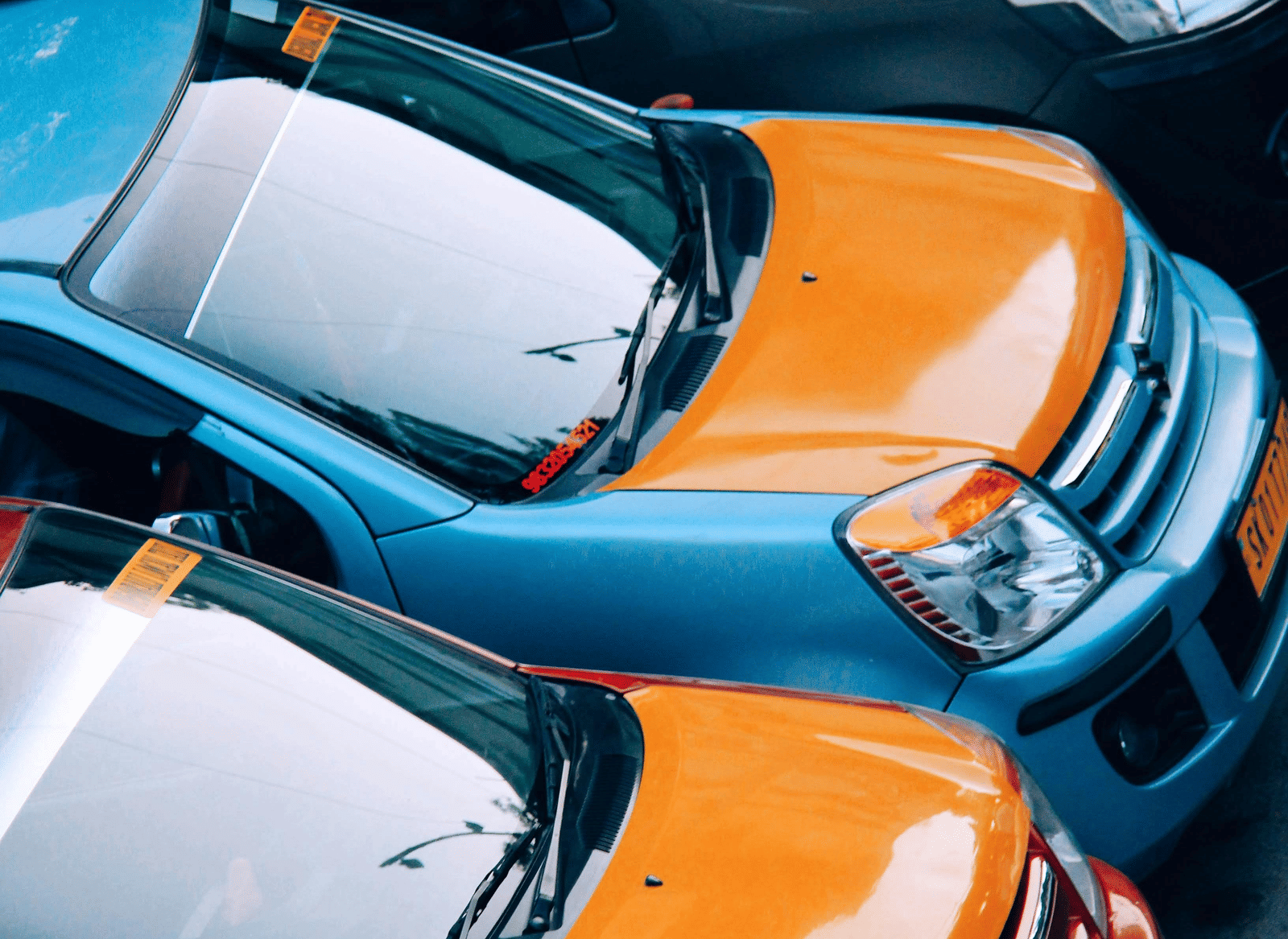 A row of car parked side-by-side in a lot.
