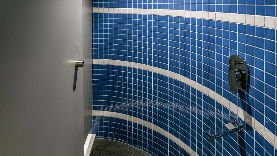 A shower area with a sliding door, illuminated by bright lighting, at Indie Stays, BKC Kalina.