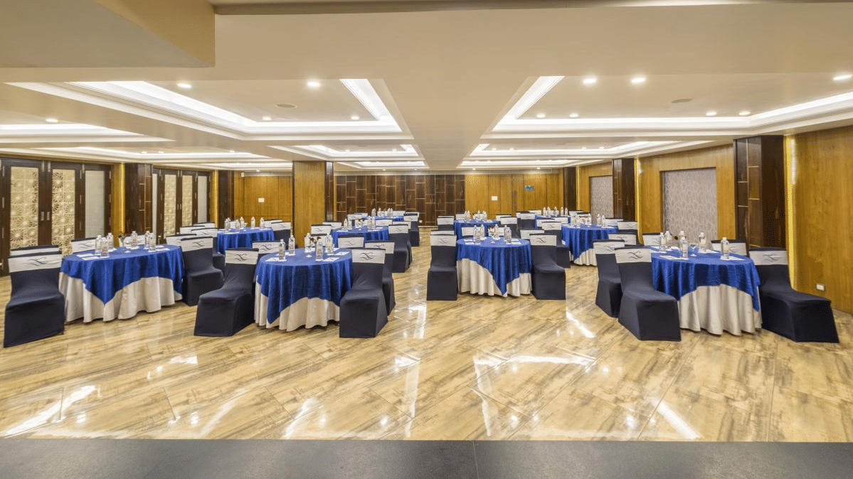 A conference room with round tables, blue tablecloths, and chairs arranged for an event - The Citrine, Bangalore