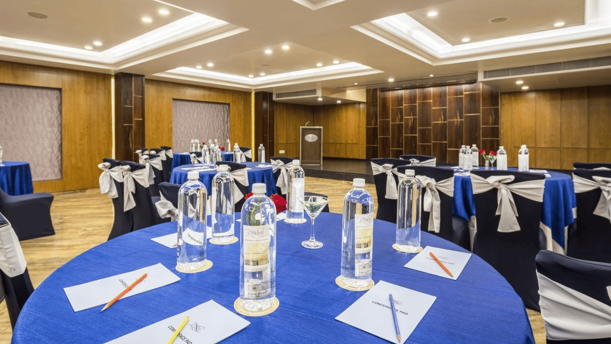 A close-up of a blue-draped conference table with water bottles and stationery - The Citrine, Bangalore
