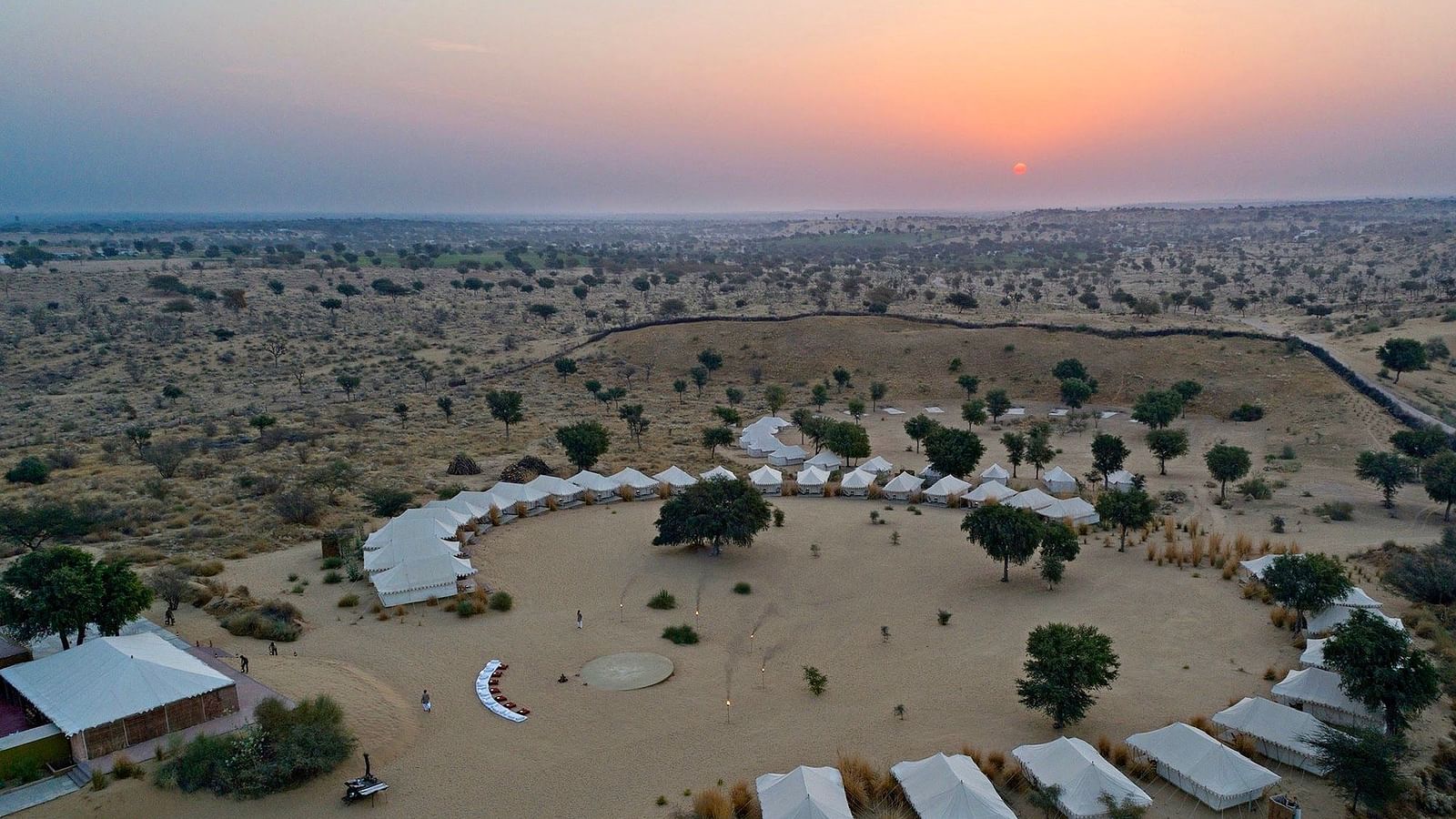 Twilight descends on the tented camp, captured from above, showing the landscape's vastness and the camp's seclusion - MANVAR Resort & Desert Camp