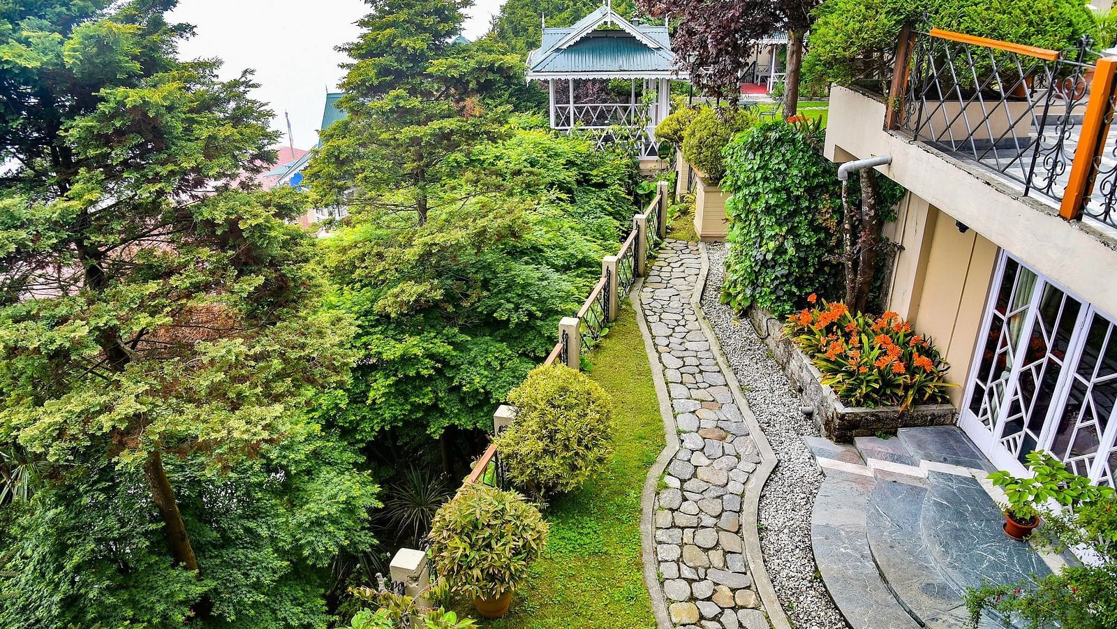 Pathway and lush greenery alongside Cedar Inn building