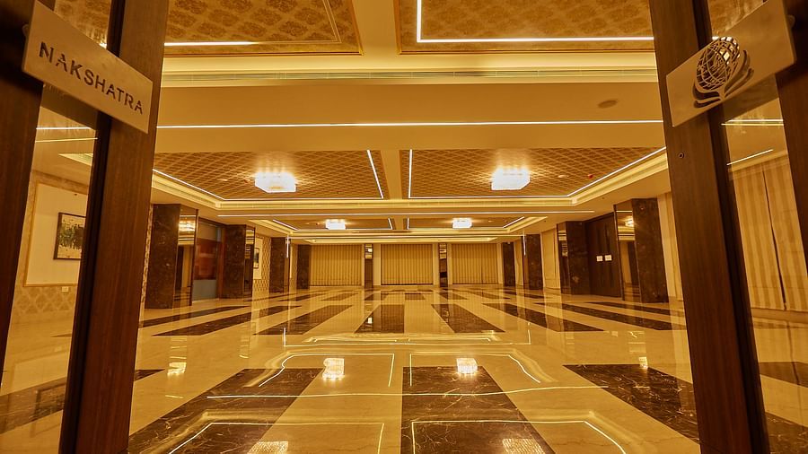 A grand, ornate hallway or lobby with a glossy tiled floor and elegant lighting,at BNGV Grandeur Hotel and Banquets.