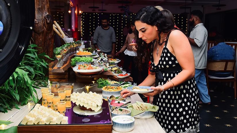 A woman selecting food from a buffet at Cloud9 Sarovar Premiere, Palolem Goa.