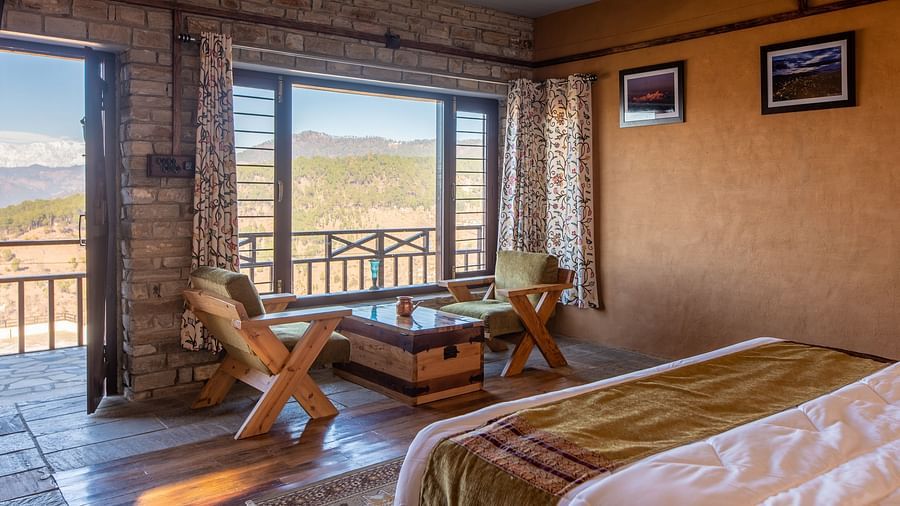 Cosy bedroom with rustic furniture and mountain view through large windows. - Blusalzz Homes The Himalayan Bungalow, Almora