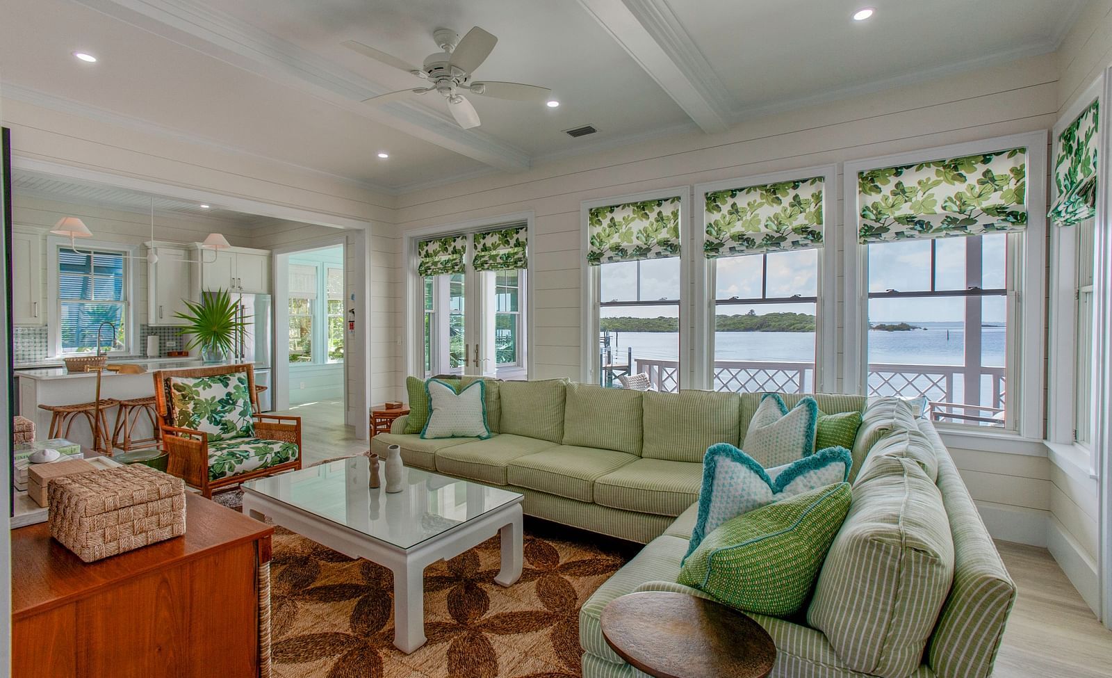A broad, inviting living area furnished with multiple sofas, a central coffee table, a television, and numerous windows a Abaco Inn, offering natural light
