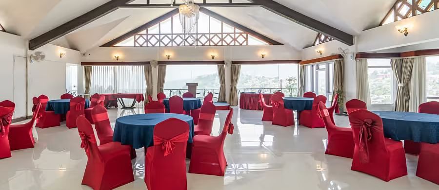 event hall with red chairs and blue table at Summit Lillium Hotel & Spa, Kalimpong