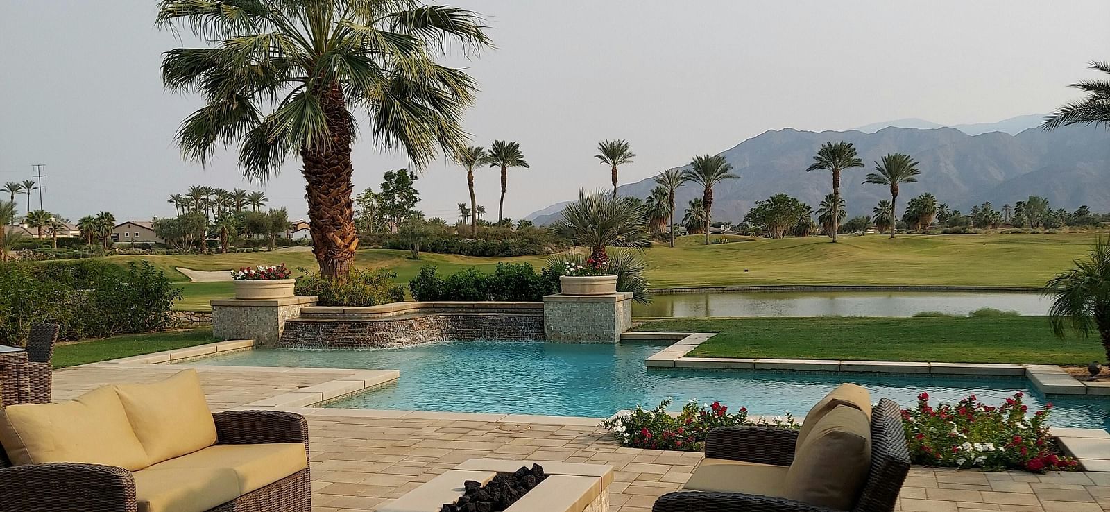 A beautiful landscape with a swimming pool along with a mountain range in the background.