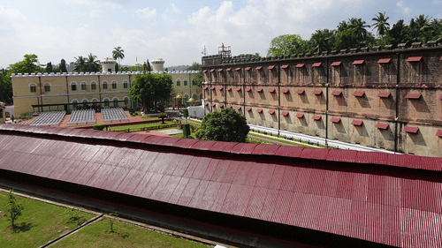 An overview of cellular jail in port blair with trees and blue sky in the background. It is the location of Light and Sound Show Port Blair.
