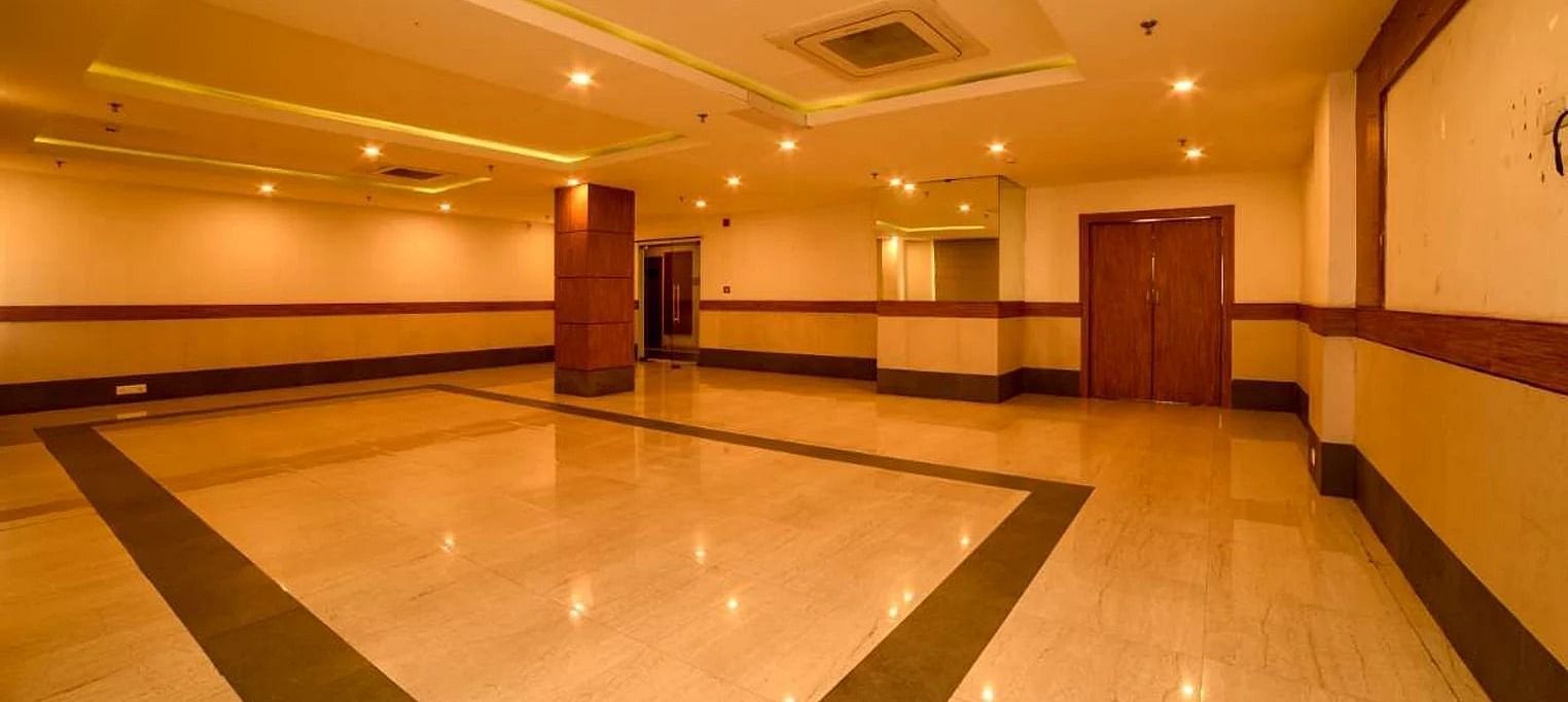 a wide angle shot of our banquet hall with warm lights installed in the false ceiling with central air-conditioning - Max Hotel, Jabalpur