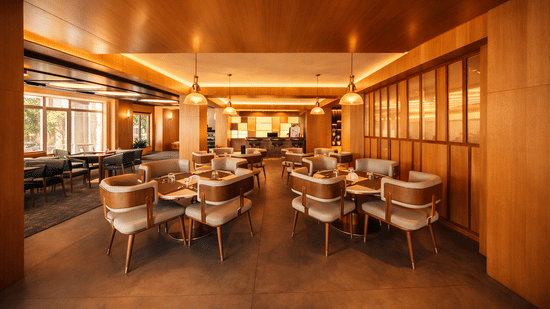 A large restaurant space with multiple tables, chairs, and wooden panelled walls | Pride Premier Darjeeling