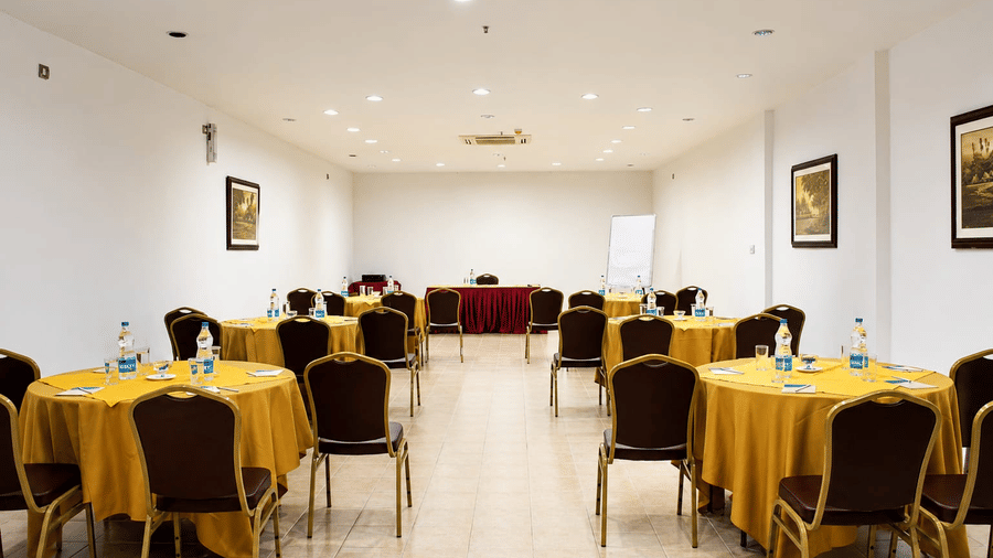 Frangi Pani Hall arranged in theatre-style seating with yellow table linens at Chariot Beach Resorts, ideal for meetings and conferences.