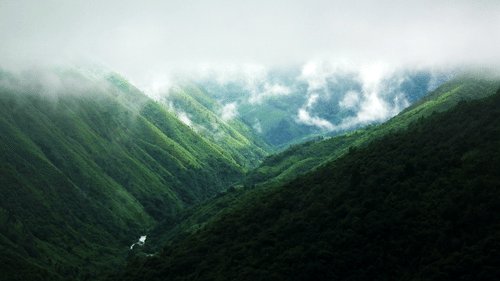 view of a hill with passing clouds