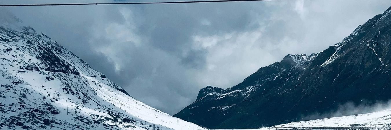 Snow-covered mountain peaks under blue sky with pristine white landscape in high-altitude region