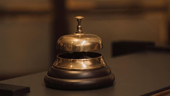 A metal service bell placed on a polished counter.
