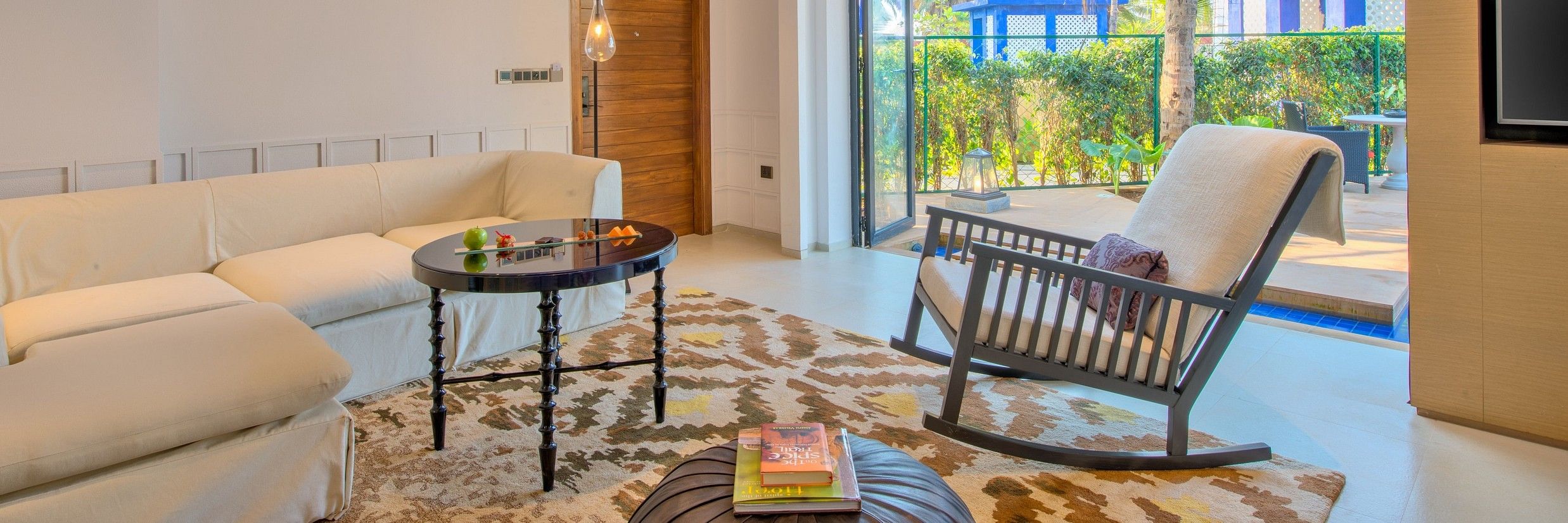 Room interiors with a rocking chair, pouffe, table and couch