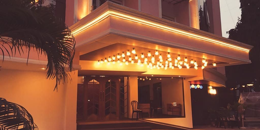 The image shows a brightly lit entrance to a hotel at night.
