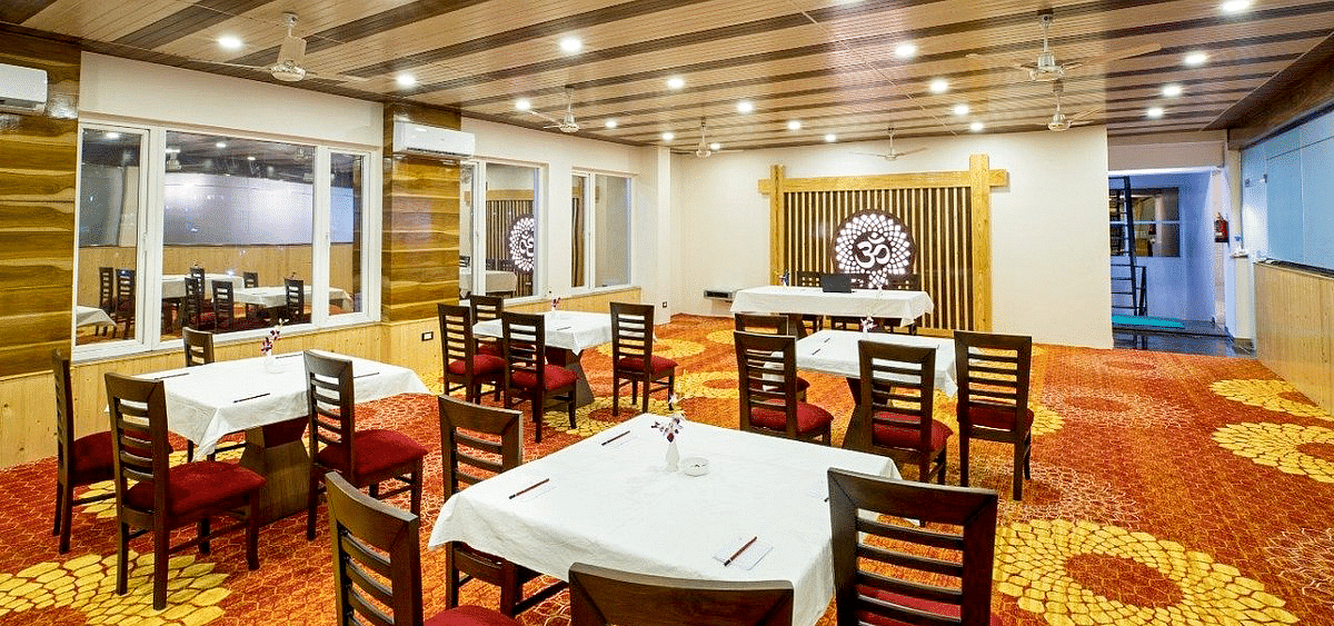 Full view shot of the Banquet Hall taken from behind featuring an Om symbol at the far end of the hall at Regenta Inn DLS.