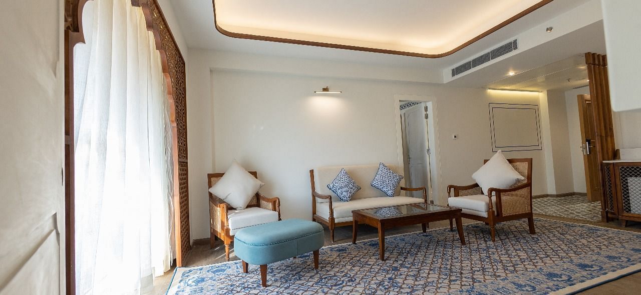Natural light coming from the arched balcony covered with white linen curtains in the living area of the Ananta at Bhagirathi by RDB Atishay.