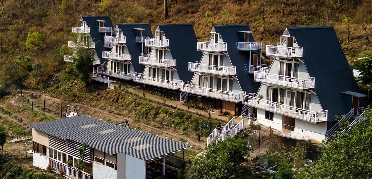 An aerial daytime view of a resort complex with multiple buildings set into a hillside landscape.