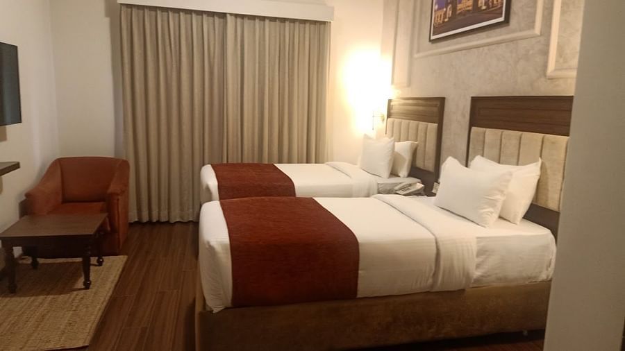 Luxury King Room with two beds, white linens, and a red runner at at Nalapad Hotel Bangalore International.