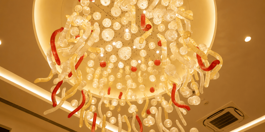 Close up view of a decorative chandelier installation inside the banquet hall at Ambrosia Sarovar Portico, Haridwar.