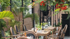 Garden café seating with cane chairs and plants at Polo Floatel Kolkata.