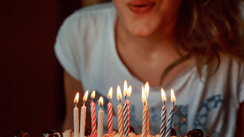 a girl blowing out candles on a birthday cake