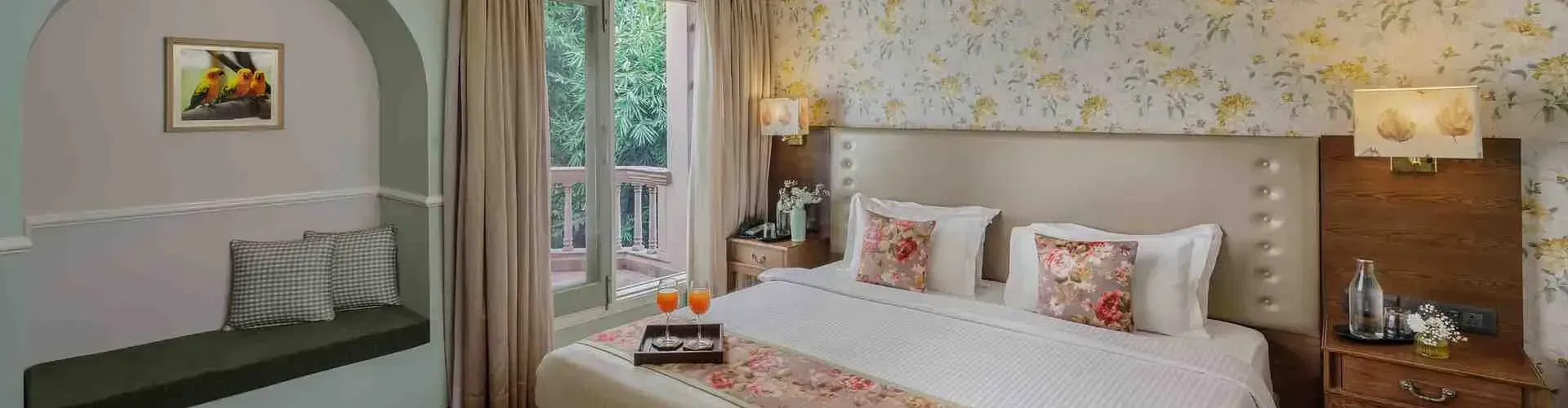 Bedroom with double bed, floral wallpaper, and balcony access at Karma Chalets
