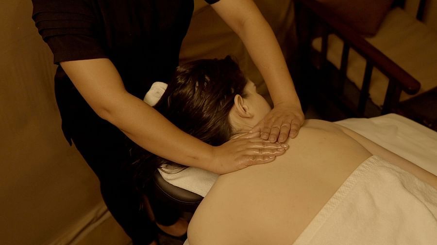 A masseuse providing a back massage in our cosy spa near Haridwar - Aalia Jungle Resort & Spa