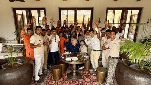 Aramness Gir team members gathered in an indoor lounge, smiling and raising their hands in celebration.