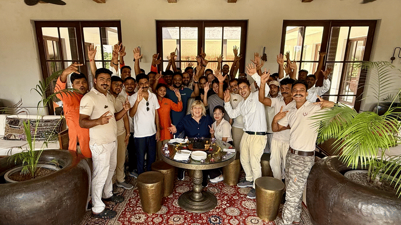 Aramness Gir team members gathered in an indoor lounge, smiling and raising their hands in celebration.