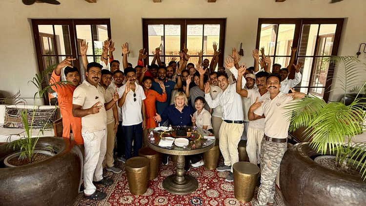 Aramness Gir team members gathered in an indoor lounge, smiling and raising their hands in celebration.
