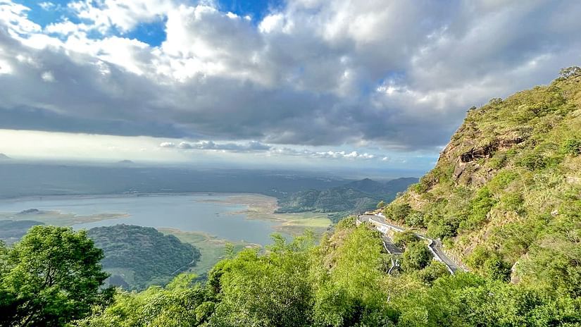 A view from the hilltop overlooking the lake with white clouds in the sky