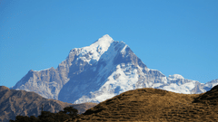 A view of nanda devi peak as seen from a hill with blue sky in the background - Naini Peak