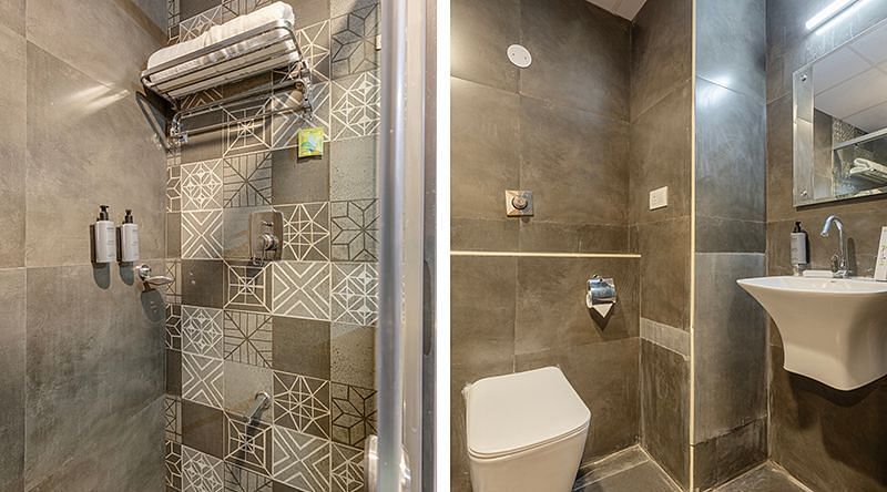 Modern bathroom with glass shower enclosure and tiled walls at Lemonridge Hotels, IDPL Balanagar.