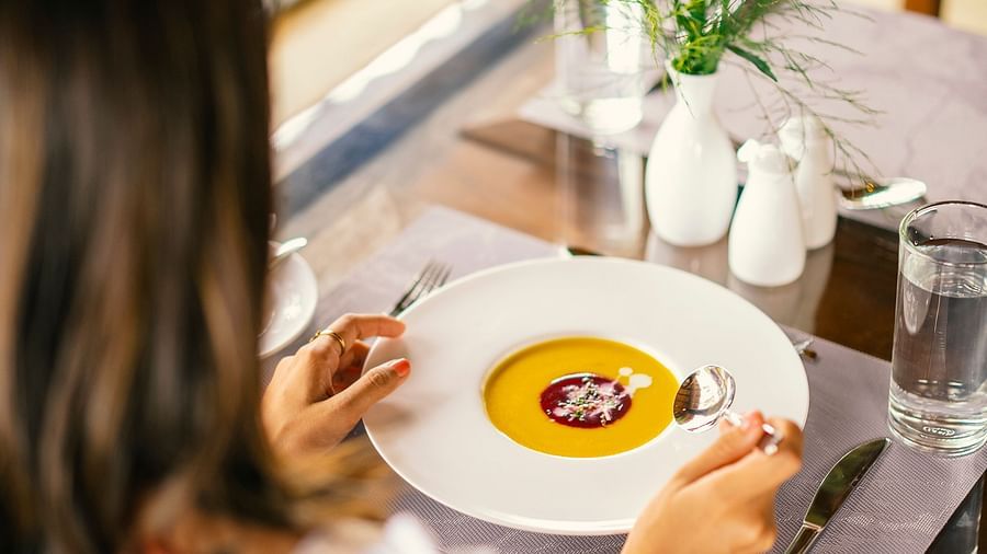 Woman dining on soup at a restaurant table