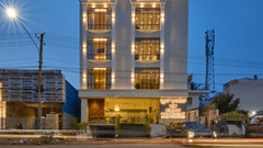 A facade image of our hotel illuminated by vibrant lights seen during an evening
